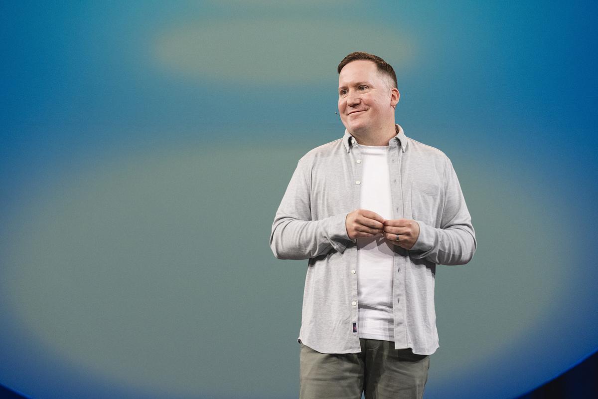 A person standing in front of a stage with a smile.